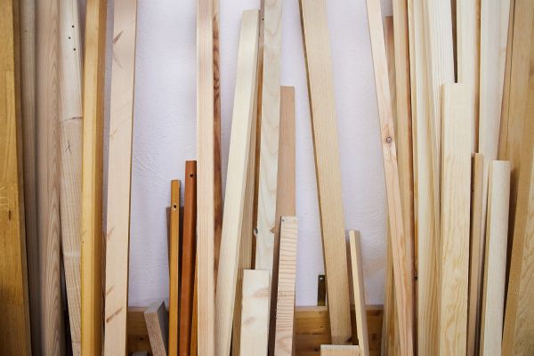 Diverse Holzlatten stehen an der Wand.